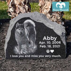 Rustic black granite pet memorial engraved with a portrait of Abby the dog, including the dates April 10, 2006 – February 18, 2021 and the inscription “I love you and miss you very much.”