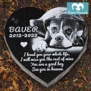 Black granite heart-shaped pet memorial engraved with a portrait of Bauer the dog and the inscription “Bauer 2012–2022,” with a heartfelt tribute message.