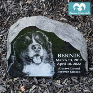 Rustic black granite pet memorial engraved with a portrait of Bernie the Bernese Mountain Dog, including his name, dates March 13, 2012 – April 10, 2022, and the inscription “Always Loved, Forever Missed.”