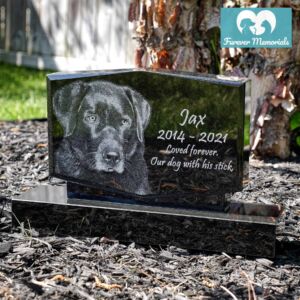 Black granite upright pet memorial engraved with a detailed portrait of Jax the dog, including the inscription “Loved forever. Our dog with his stick.” and the dates 2014–2021.