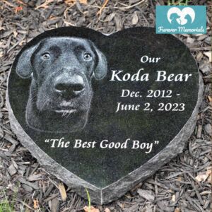 Black granite heart-shaped pet memorial engraved with a portrait of Koda Bear the dog and the inscription “Our Koda Bear, Dec. 2012 – June 2, 2023 – The Best Good Boy.”