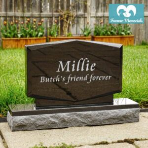 Black granite upright pet memorial headstone engraved with the name Millie and the inscription “Butch’s friend forever,” displayed in a backyard garden setting.
