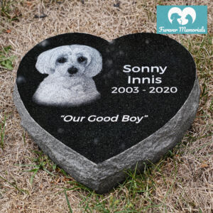 Heart-shaped black granite pet memorial engraved with a portrait of Sonny Innis the dog, including the inscription “Our Good Boy” and the dates 2003–2020.