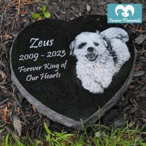 Black granite heart-shaped pet memorial engraved with a portrait of Zeus the dog and the inscription “Zeus 2009–2023 – Forever King of Our Hearts.”